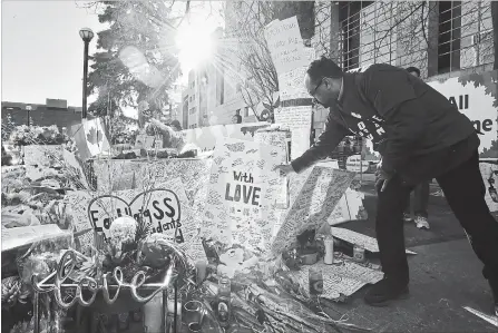  ?? FRANK GUNN THE CANADIAN PRESS ?? A man places a placard before a vigil rememberin­g the victims of the deadly van attack, at Mel Lastman Square in Toronto on Sunday.