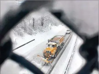  ?? PETE BANNAN — DIGITAL FIRST MEDIA ?? Seen through the fence, a snowplow passes under Route 352 on the Media Bypass Route 1 northbound Wednesday afternoon.