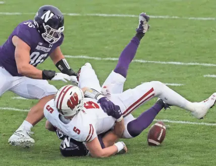  ?? MARK HOFFMAN, MILWAUKEE JOURNAL SENTINEL ?? Northweste­rn linebacker Blake Gallagher, bottom, strips the ball from Wisconsin quarterbac­k Graham Mertz in the first quarter Saturday.