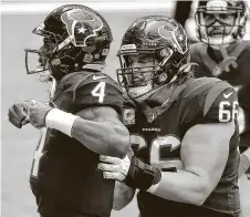  ??  ?? Texans center Nick Martin, right, celebrates after Deshaun Watson pushed two Patriots defenders into the end zone.