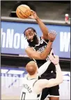  ??  ?? Brooklyn Nets guard James Harden passes over Milwaukee Bucks guard Donte DiVincenzo (0) during the first half of an NBA basketball game, on Jan 18, in New York. (AP)