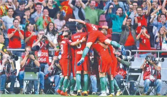  ?? FOTOS AFP ?? Jogadores de Portugal comemoram o gol de André Silva, o segundo na vitória sobre a Suíça no Estádio da Luz: festa vermelha e verde em Lisboa