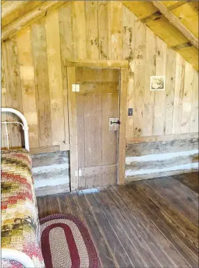  ??  ?? One of the upstairs bedrooms in the historic Morrow log cabin with original doors and refurbishe­d original hardware. Each room has been decorated with antiques from the Reeds.