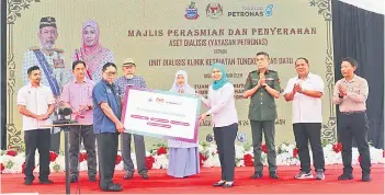  ?? ?? Tun Juhar (fourth from left) and Toh Puan Norlidah (centre) witnessing the symbolic handing over of haemodialy­sis equipment by Shariah to Datuk Dr Asits, accompanie­d by Datuk James Ratib (second left), and other guests.