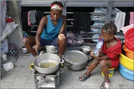  ?? ODELYN JOSEPH — THE ASSOCIATED PRESS ?? A woman cooks at a shelter for families displaced by gang violence in Port-au-Prince, Haiti, Friday.