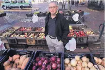  ?? CHARLES KRUPA/ASSOCIATED PRESS ?? John Gold, a self-employed graphics designer, visits a farmers market outside his office in Portland, Maine, on Wednesday. Gold plans to shop for plans for 2020 again.