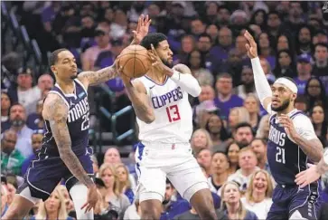  ?? TONY GUTIERREZ Associated Press ?? THE CLIPPERS’ Paul George looks to pass as the Mavericks’ Moussa Diabate (25) and Kobe Brown (21) defend during the second half of Game 3 on Friday. George had just seven points and five rebounds in the loss.