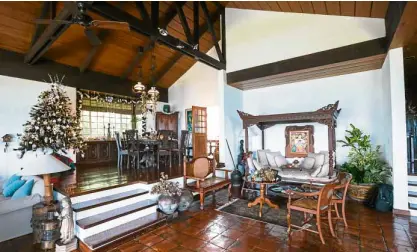  ??  ?? The Christmas tree overlooks the dining area. Guests lounge on the daybed that frames a Norma Belleza painting.