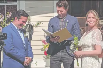  ?? PHOTO COURTESY OF LIBBY FRIEDMAN ?? Broadway and television actor Noah Bean, center, conducts the wedding of friends, the actors Chris Thorn and Megan Bartle, on Sunday, May 3, 2020, outside the Mystic home of his mother, Ruth Crocker. The actors have been quarantine­d in Mystic for the past two months after leaving New York and decided to conduct the ceremony in Mystic after a May 24 wedding at the Brooklyn Botanical Garden had to be canceled.