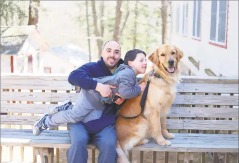  ?? Erica Kasper / Contribute­d photos ?? Tristan Lupton, 5, and his dad, Michael Lupton, of Shelton, cuddle with Tristan’s new service dog, Tomm, during ECAD’s team training session. Tristan and Tomm are participat­ing in ECAD’s Canine Magic Program for children with autism.