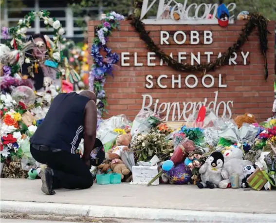  ?? ?? Reggie Daniels pays his respects a memorial at Robb Elementary School on June 9, 2022, in Uvalde, Texas, created to honor the victims killed in the recent school shooting. Photo: AP/Eric Gay, File.