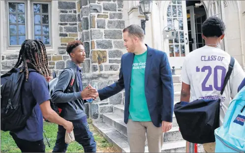  ?? JACQUELYN MARTIN/THE ASSOCIATED PRESS ?? Joseph Webb, principal at Washington Leadership Academy, greets students, including Malik Mitchell (left), as they arrive for school in the morning in Washington, D.C. The school uses “personaliz­ed learning,” an approach that uses software, data and...