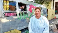  ?? STAFF PHOTO BY TIM OMARZU ?? Virginia Cofer, owner of Petunia’s Silver Jalapeño, stands outside the eatery’s Airstream Internatio­nal trailer kitchen Friday afternoon, while Justin Smith works inside at the take-out window.