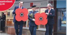  ??  ?? Air Marshal Stuart Atha (centre) with John Strickland, The MacRobert Trust (left) and Poppyscotl­and’s Mark Bibbey at the Kilmarnock centre