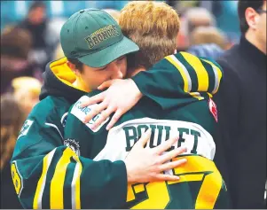  ?? CP PHOTO ?? Mourners comfort each other during a vigil at the Elgar Petersen Arena, home of the Humboldt Broncos, to honour the victims of a fatal bus accident in Humboldt, Sask., on Sunday.