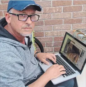 ??  ?? John Weller, who had his boat damaged by rats at his Niagara Falls home, checks informatio­n on his laptop.