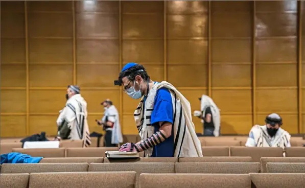  ?? Andrew Rush/Post-Gazette ?? Gavriel Levy, of Oakland, participat­es in the daily morning prayer service Friday at Shaare Torah in Squirrel Hill.