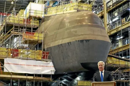  ?? GETTY IMAGES ?? Former British defence secretary Michael Fallon speaks to workers building the new Dreadnough­t nuclear missile submarines at the BAE Systems shipyard in Barrow-in-Furness, England. The Aukus programme proposes building 10 nuclear submarines at a time when British and American shipyards already have their hands full.
