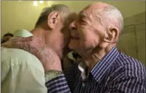  ?? SEBASTIAN SCHEINER, THE ASSOCIATED PRESS ?? Israeli Holocaust survivor Eliahu Pietruszka, right, embraces Alexandre Pietruszka as they meet for the first time in Kfar Saba.