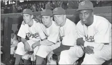  ?? HARRY HARRIS — THE ASSOCIATED PRESS FILE ?? Brooklyn Dodgers players, from left, third baseman John Jorgensen, shortstop Pee Wee Reese, second baseman Ed Stanky, and first baseman Jackie Robinson pose before the 1947 opener at Ebbets Field in Brooklyn.