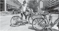  ?? Steve Gonzales / Staff photograph­er ?? “I use it all the time to go and get coffee or to run quick errands,” Gisele Caleron says as she checks out a BCycle bike in the Medical Center.