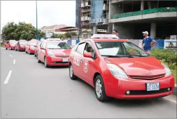  ?? HONG MENEA ?? Taxi Rouge vehicles wait for customers yesterday afternoon in the Kingdom’s capital.