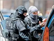  ?? BORIS HORVAT/GETTY-AFP ?? French police officers leave a suspect’s apartment after a raid Tuesday in Marseille. Police arrested two French men.