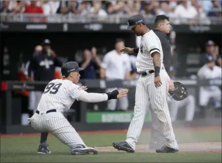  ?? TIM IRELAND — THE ASSOCIATED PRESS ?? New York Yankees’ Aaron Judge, left, and Aaron Hicks celebrate after scoring on a single by Gary Sanchez during the seventh inning of a baseball game against the Boston Red Sox in London, Sunday, June 30, 2019.