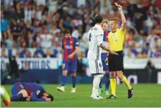  ?? AP ?? Real Madrid’s Sergio Ramos is shown the red card by the referee after fouling Messi.