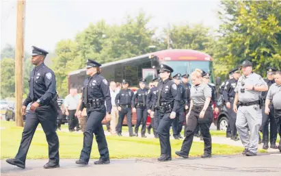  ?? SOFIE BRANDT/HARTFORD COURANT ?? Police officers walk toward the Samsel and Carmon funeral home to attend a wake for South Windsor police Officer Benjamin Lovett, 25, who died last week from injuries sustained when his motorcycle was hit by a pickup truck.