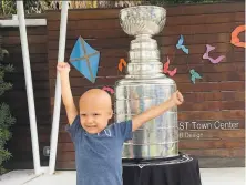  ?? Photos by Kristina Hjertkvist / Associated Press ?? Kameron Bush, 3, poses with the Stanley Cup at a cancer center in Tampa on its tour following the Lightning’s title.