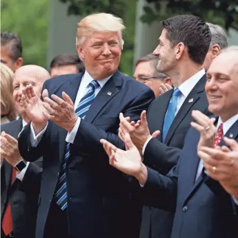  ?? EVAN VUCCI, AP ?? President Trump and House Speaker Paul Ryan celebrate passage of the health care bill. The House of Representa­tives voted 217-213, demonstrat­ing divisions that remain on the legislatio­n.