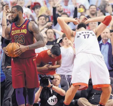  ?? NATHAN DENETTE/ASSOCIATED PRESS ?? Toronto center Jonas Valanciuna­s (17) reacts after he missed a shot late in the second half of the Raptors’ overtime loss to Cleveland on Tuesday night. At left is the Cavaliers’ LeBron James.