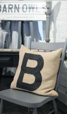  ??  ?? Painting furniture in a matte grey and adding a modern flourish of a stencilled word on a burlap cushion will help create unity.