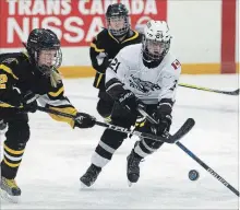  ?? CLIFFORD SKARSTEDT EXAMINER ?? Peterborou­gh Ice Kats’ Annabelle Leclair fights for the puck against Waterloo Ravens’ Brooke Taylor in Peewee B division during opening day of 38th PGHA Ice Kats Tournament Friday at the Kinsmen Civic Centre.