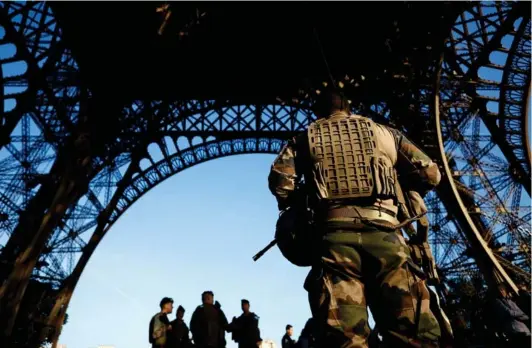  ?? ?? ► Soldados franceses del plan Vigipirate asegurando la Torre Eiffel.