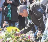  ?? MICHAEL CAMPANELLA, GETTY IMAGES ?? A man leaves flowers on Sergels square during a peace demonstrat­ion Sunday in Stockholm. Four people were killed in a truck attack.