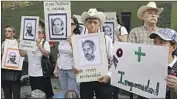  ?? Luis Romero Associated Press ?? DEMONSTRAT­ORS HOLD pictures of slain Jesuit priests and demand justice in San Salvador in 2011.