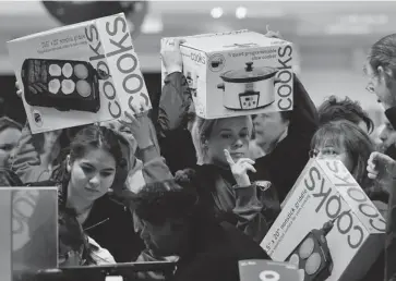  ?? JULIE JACOBSON/THE ASSOCIATED PRESS FILES ?? Shoppers rush to grab electric griddles and slow cookers during last year’s Black Friday sale at a JC Penny in Las Vegas. The annual American discount sale day draws large numbers of Canadian shoppers over the border each year.