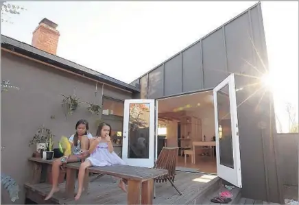  ??  ?? ENNA AND LEAH hang out on the back porch of their home, which received an update by architect Talbot McLanahan.