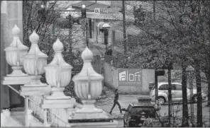  ?? Arkansas Democrat-Gazette/STEPHEN B. THORNTON ?? A woman crosses Main Street at Capitol Avenue on Wednesday near a constructi­on project in downtown Little Rock. Downtown property owners spoke Wednesday against a proposed downtown design district that would run from Markham Street to Interstate 630...