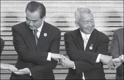  ?? EPA ?? Foreign Affairs Secretary Perfecto Yasay Jr. (right) links arms with China’s Foreign Minister Wang Yi for a group photo during the ASEAN Plus Three Foreign Ministers Meeting in Vientiane, Laos yesterday.