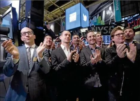  ?? ASSOCIATED PRESS ?? TWITTER CEO Dick Costolo, Chairman and co-founder Jack Dorsey, and co-founders Evan Williams and Biz Stone, front row left to right, applaud as they watch the New York Stock Exchange opening bell rung, on Thursday.
