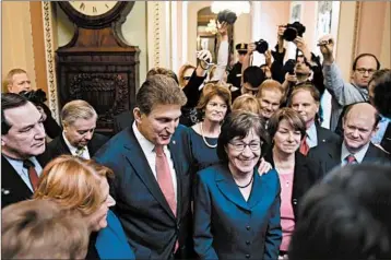  ?? MATT MCCLAIN/WASHINGTON POST ?? Sen. Joe Manchin, D-W.Va., and Sen. Susan Collins, R-Maine, gather with other lawmakers to address the media.