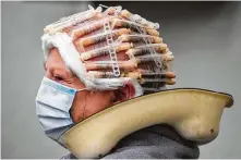  ?? Jens Buettner / Associated Press ?? Customer Ilse Kopsch sits in a hairdressi­ng salon with mouth guards and curlers Monday in Greifswald, Germany.