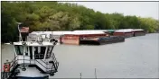  ?? ASSOCIATED PRESS ?? IN THIS MAY 14 PHOTO, empty barges are moored on the Mississipp­i River in St. Paul, Minn., as spring flooding interrupts shipments on the river.