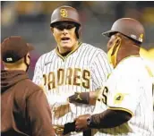  ?? K.C. ALFRED U-T ?? A trainer (left) checks on Manny Machado during Friday night’s game against the Dodgers.