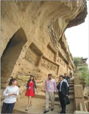  ?? LIU JIYUAN / FOR CHINA DAILY ?? Reporters pay a visit to Red Rock Canyon, a scenic riverside path dotted with historic grottoes.