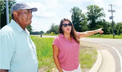  ??  ?? District 4 Supervisor Bricklee Miller, right, points out the spot where a new traffic signal will go at the intersecti­on of Old Highway 25 and Poorhouse Road while District 5 Supervisor Joe Williams looks on. The county received $1.5 million from the state for work on Poorhouse Road and Blackjack Road. (Photo by Charlie Benton, SDN)