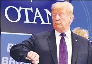  ?? AP PHOTO ?? U.S. President Donald Trump checks time prior to a dinner of leaders at the Art and History Museum at the Park Cinquanten­aire in Brussels on Wednesday.